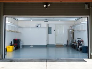 Epoxy floor cracking in organised garage with shelves and storage, showing damage risk from heavy loads.