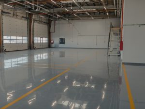 Spacious commercial area with smooth epoxy flooring, highlighting potential areas prone to chipped epoxy floor damage.